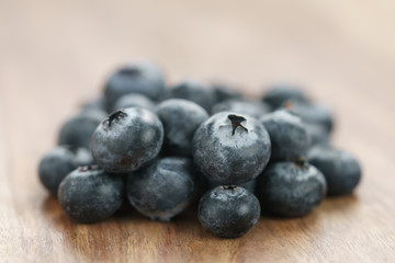 heap of fresh garden blueberries on wood table, closeup photo