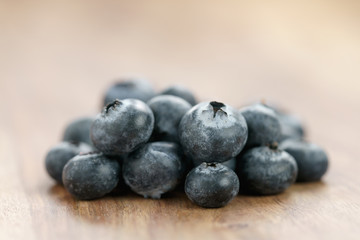 Fototapeta na wymiar heap of fresh garden blueberries on wood table, closeup photo