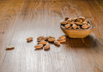 almond from wooden bowl on wooden board