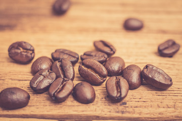 Roasted coffee beans on wood texture background. vintage color effected