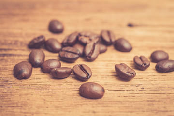 Roasted coffee beans on wood texture background. vintage color effected
