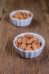 almond in porcelain bowl on wooden board