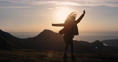 Woman dancing silly freestyle dance at sunset freedom celebration Crazy dancer girl having fun enjoying nature celebrating vacation travel adventure Scotland