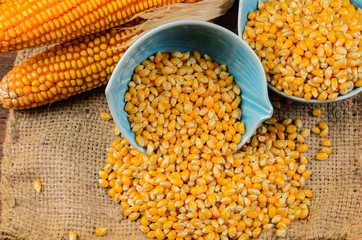 Dried corn in blue ceramic bowl on wooden table