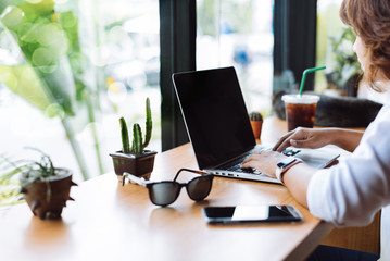 Asian girl working at a coffee shop with a laptop.female freelancer connecting to internet via computer.