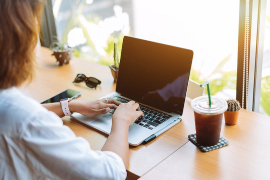 Asian Girl Working At A Coffee Shop With A Laptop.female Freelancer Connecting To Internet Via Computer.