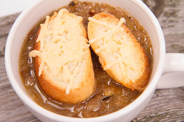 Onion soup with toast on a wooden background