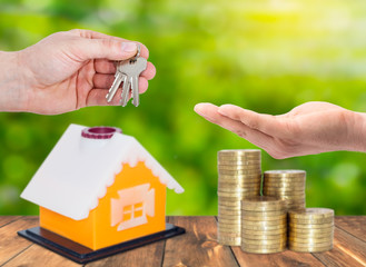 Sale and rental properties,loans for real estate concept. A realtor hand gives keys for home with...