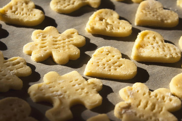 Golden home made cookies ready to bake on the baking paper.