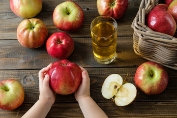 large ripe apple in children's hands