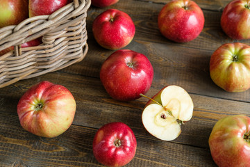 basket with red ripe apples on a brown wooden table