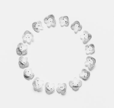 Round vintage frame of small flowers on a white background with space for text, black and white photo. Flat lay, top view