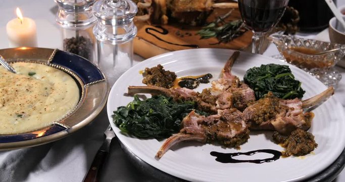 Dolly view of a rack of lamb with crusted mint sauce and mashed potatoes