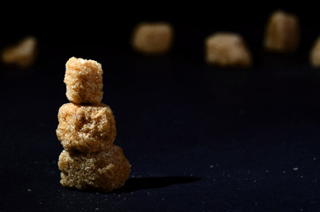 cane sugar on black background pile