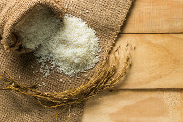 Jasmine rice in sack on wood table,top view