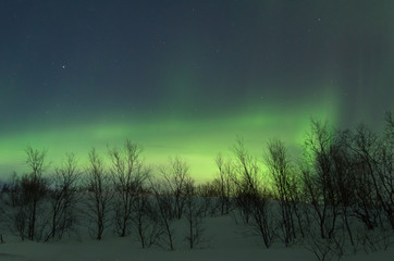 The hills are covered with snow and the Aurora .Night.