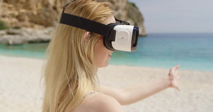Sexy Young woman on tropical beach wearing virtual reality headset watching 360 travel video imagination concept enjoying summer vacation