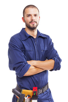 Young worker standing with arms crossed on white background