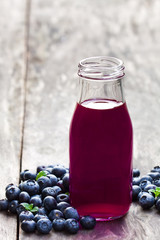 Blueberry  juice in glass bottle on wooden table © lena_zajchikova