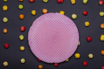 colorful tasty dragee sweets and round pink wafer or waffle