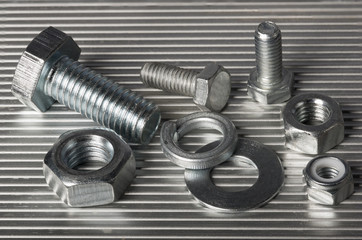 Washers,  bolts and nuts on the aluminum background.