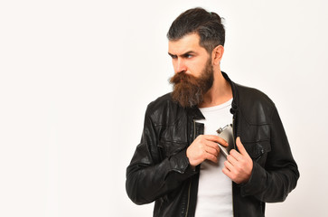 serious bearded man hipster with metallic jar in leather jacket