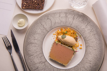 Laying of parfait from a liver of a guinea fowl with tableware, bread and oil