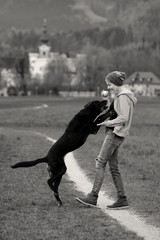 Junge Frau spielt mit ihrem Hund mit einem Ball