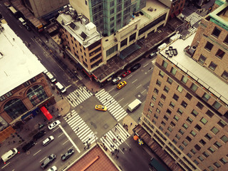 Bird's eye view of midtown Manhattan from a tall skyscraper. Looking down on New York yellow taxis and busy street of New York City. Looking down on Manhattan's 5th Avenue. Filter added.