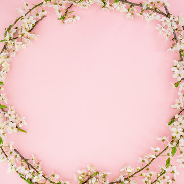 Spring time background. Frame of spring flowers on pink background. Flat lay, top view.