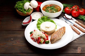 Business lunch. Soup and the second dish. Wooden table.