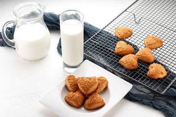 Cookies. freshly baked heart homemade biscuits with a cup of milk over white background.