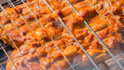 the chicken is fried on the grill grate on the grill.