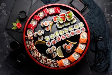 Obraz na płótnie Canvas Japanese cuisine. Asian food. Sushi set on a wooden round plate. Stone background.