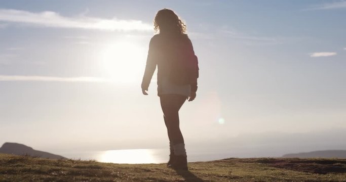 Woman with arms raised on top of mountain looking at Sunset view Hiker Girl lifting arm up celebrating life scenic nature landscape enjoying vacation travel adventure Isle of Skye Scotland