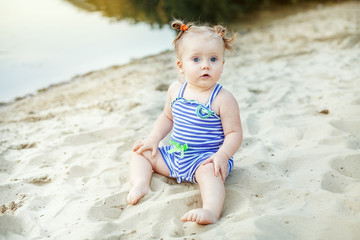 Small kid girl playing in the sand. The concept of childhood, leisure and lifestyle.