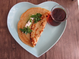 heart shaped pancakes and tea in a bowl on a wooden floor
