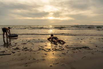 Two child playing rubber ring on the beach