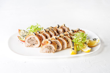 Chicken roll stuffed mushrooms on a white plate. The concept of nourishing food.