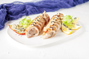 Chicken roll with mushrooms and slices of lemon and Frize. White background. The concept of nourishing food.