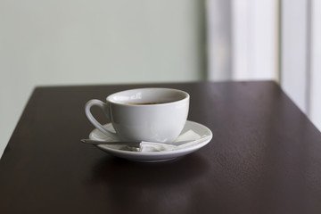 Fresh coffee in white cup on wooden table