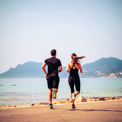Homme et femme faisant de la course à pied: footing du matin au bord de mer