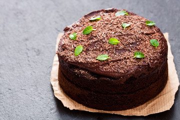 Belgian  chocolate fudge cake on black stone background
