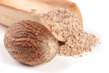 nutmeg with powder in a scoop isolated on white background
