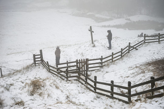 Beautiful Winter landscape image around Mam Tor countryside in Peak District England with members of public playing in snow