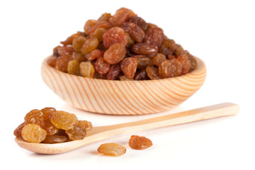 raisins in a wooden bowl with spoon isolated on white background