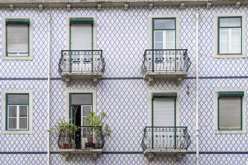 Hauswand in Lissabon mit blauen Fliesen und acht Fenstern