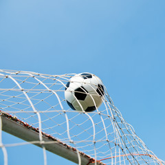 soccer ball in goal. isolated on blue sky background.