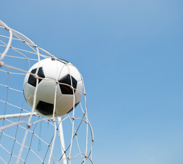 soccer ball in goal. isolated on blue sky background.