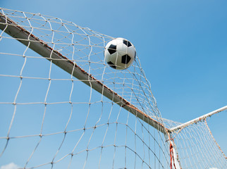 soccer ball in goal. isolated on blue sky background.